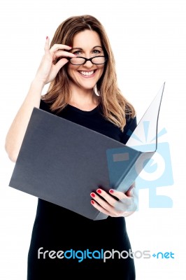 Smiling Corporate Woman Holding Open Folder Stock Photo