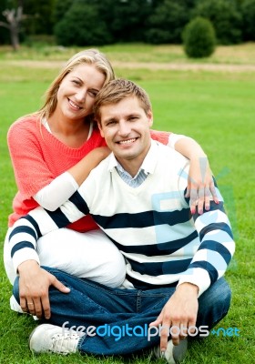 Smiling Couple Sitting In Outdoor Stock Photo