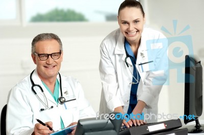 Smiling Doctor Typing On Keyboard Stock Photo