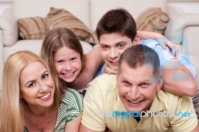 Smiling Family Lying Together On The Floor Stock Photo