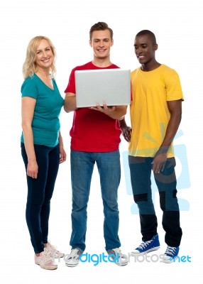 Smiling Friends Using Laptop Stock Photo