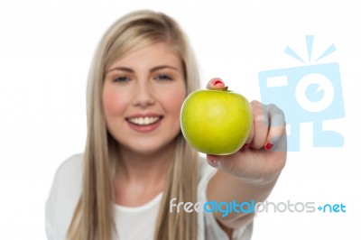 Smiling Girl Displaying Fresh Green Apple To The Camera Stock Photo
