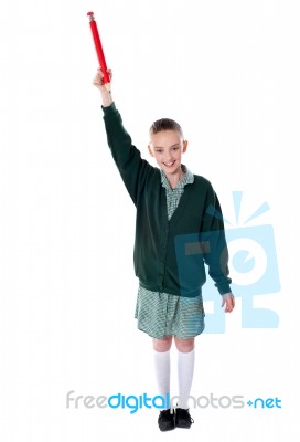 Smiling Girl Holding Pencil Upward Stock Photo