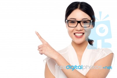 Smiling Girl Wearing Eyglasses Pointing Away Stock Photo
