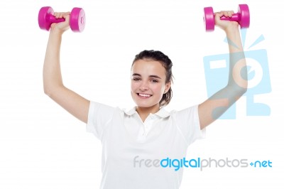 Smiling Girl Working Out. Dumbbells Above Her Head Stock Photo
