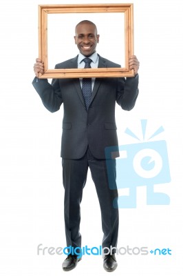 Smiling Guy Looking Through Picture Frame Stock Photo