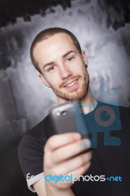 Smiling Male Holding Smartphone Stock Photo