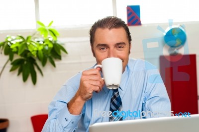 Smiling Male Manager Enjoying Hot Coffee Stock Photo