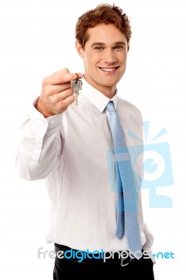 Smiling Man Offering House Key Stock Photo