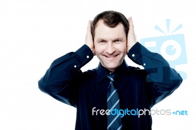 Smiling Man With Hands On His Ears Stock Photo
