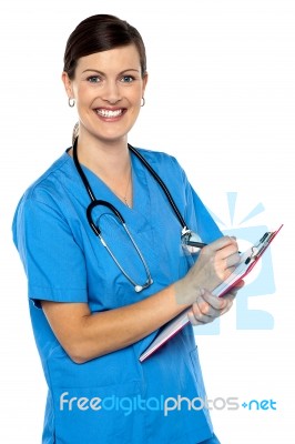 Smiling Medical Practitioner Filling Out The Records Stock Photo