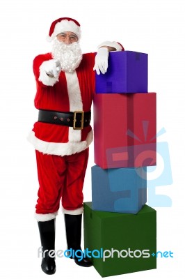 Smiling Santa Posing Beside Presents Stock Photo