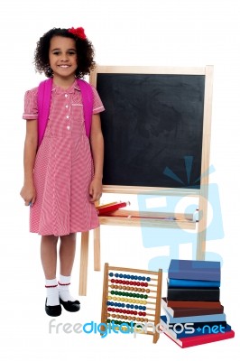 Smiling School Girl Standing Near The Blackboard Stock Photo