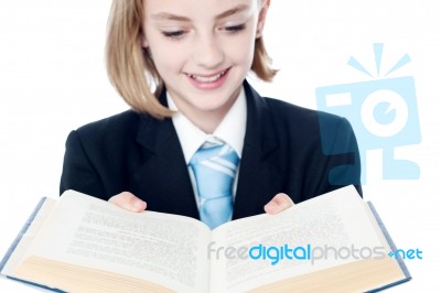 Smiling Teen Girl Looking At A Book Stock Photo