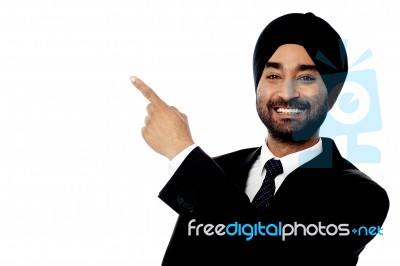 Smiling Young Businessman Pointing Away Stock Photo