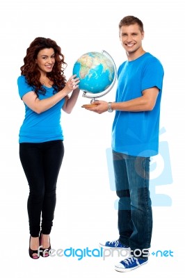 Smiling Young Couple Holding Globe Stock Photo
