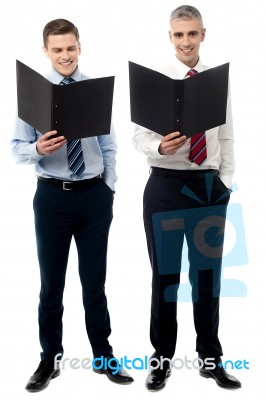 Smiling Young Executives With Folder Stock Photo