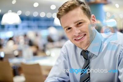 Smiling Young Man Relaxing In Restaurant Stock Photo
