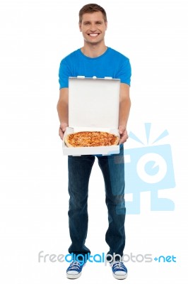 Smiling Young Man Showing Pizza box Stock Photo