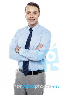 Smiling Young Team Leader Keeping His Arms Folded Stock Photo