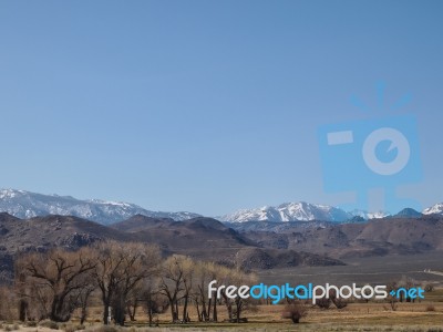 Snow Capped Mountains, Blue Sky, Desert Landscape Stock Photo