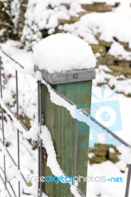 Snow On Wooden Pole And Fence Stock Photo