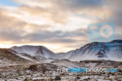 Snowy Icelandic Mountains With Dramatic Cloudy Sky Stock Photo