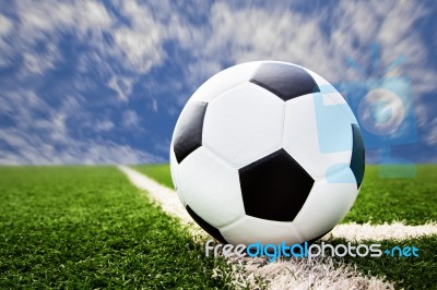 Soccer Ball On Grass Field With Blue Sky Stock Photo