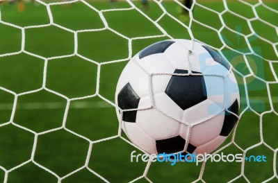 Soccer Football In Goal Net With Green Grass Field Stock Photo