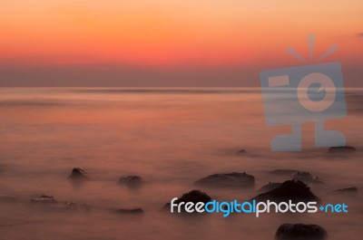Soft Waves On A Rocky Beach In The Evening Stock Photo