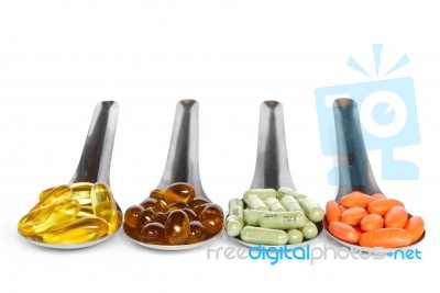 Spoons With Colorful Vitamin Medicine Pills Stock Photo