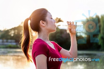 Sporty Woman Drinking Water On Sunlight Stock Photo