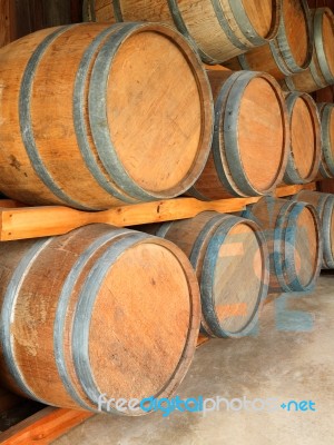 Stack Of Round Wooden Wine Barrels In Cellar Shelf Stock Photo