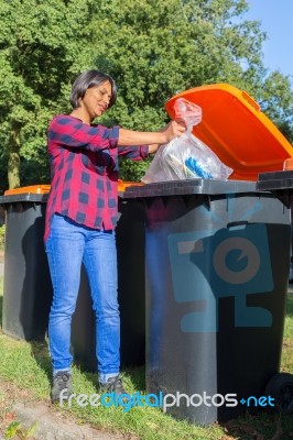 Standing Dutch Woman Dropping Plastic Waste In Trash Bin Stock Photo