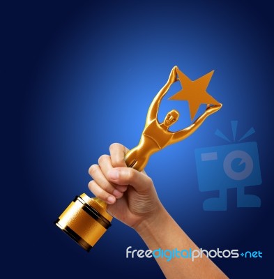 Star Award In Hand Isolated On Blue Background Stock Photo