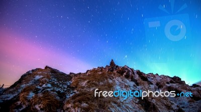 Star Trails Over The Winter Mountains Landscape Stock Photo