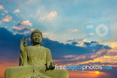 Statue Of Buddha At Peace With Sunset Background Stock Photo