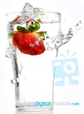 Strawberry Dropping Into Glass Stock Photo