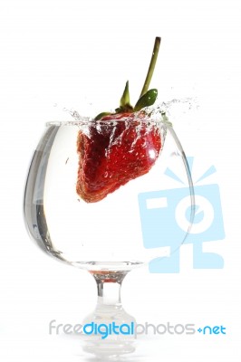 Strawberry Dropping Into Water Glass Stock Photo