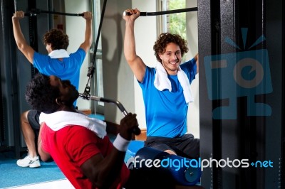 Strong Young Guys Toning Their Upper Body In Gym Stock Photo
