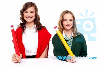 Students Writing With Big Pencil Stock Photo