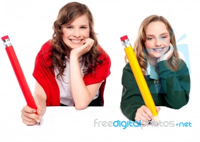 Students Writing With Big Pencil Stock Photo