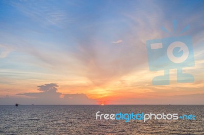 Sun Set At Sea With Blue Sky And Clouds Stock Photo