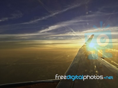 Sun Set On Horizon Cloud Sky  Through Airplane Wing Stock Photo