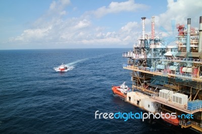 Supply Boat Transfer Cargo To Oil And Gas Industry And Moving Cargo From The Boat To The Platform Stock Photo