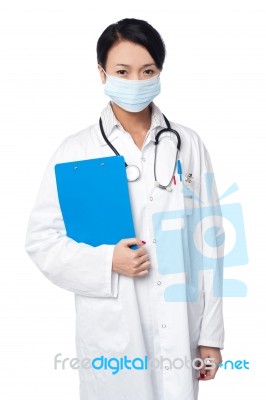 Surgeon Holding Clipboard. Face Covered With Surgical Mask Stock Photo