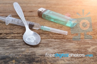 Syringe And Drug And Spoon Cooked Heroin On A Wooden Background Stock Photo