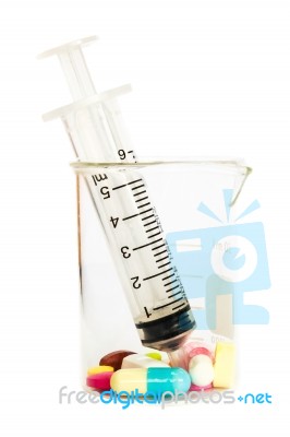 Syringe In Beaker And Group Of Drugs Stock Photo