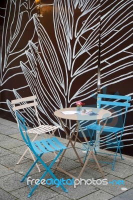 Table And Chairs In A Street In Munich Stock Photo