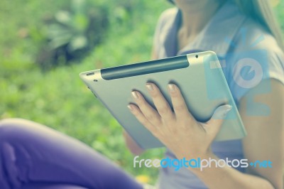 Tablet Computer On Hand Of Beautiful Young Woman In Park Stock Photo